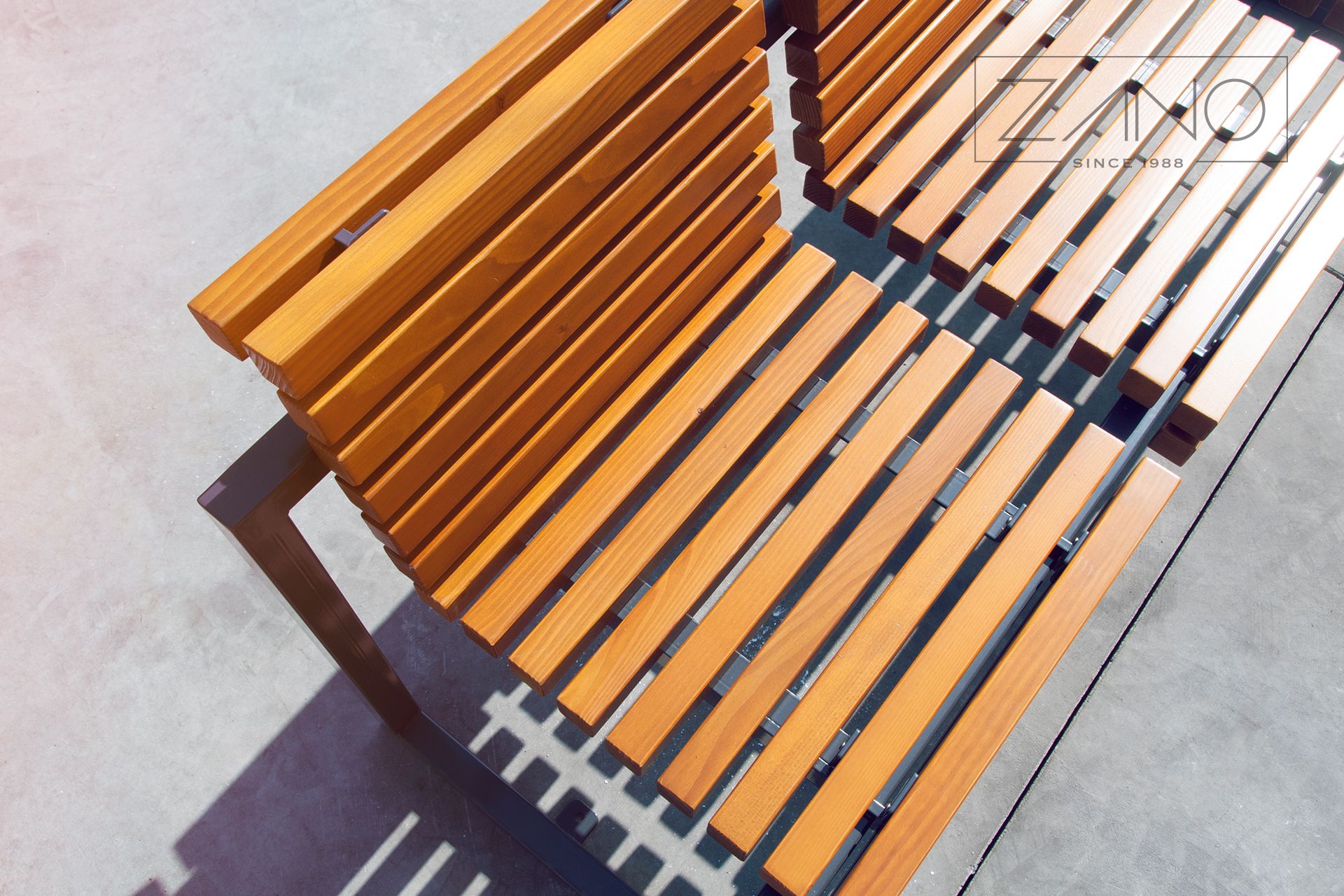 Nowoczesna ławka miejska z cienkich desek przytwierdzonych do stalowej malowanej konstrukcji